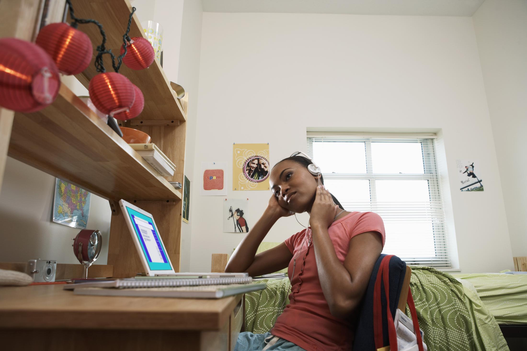 girl sitting at a desk listening to headphones