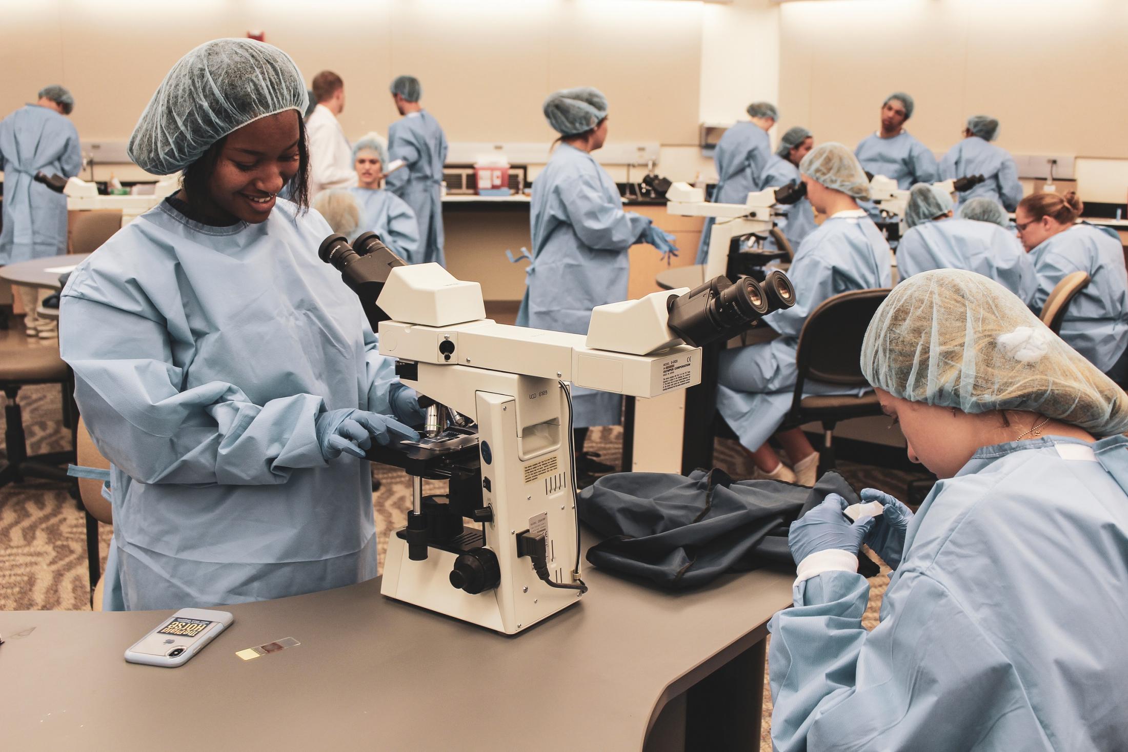 Students checking out samples under a microscope